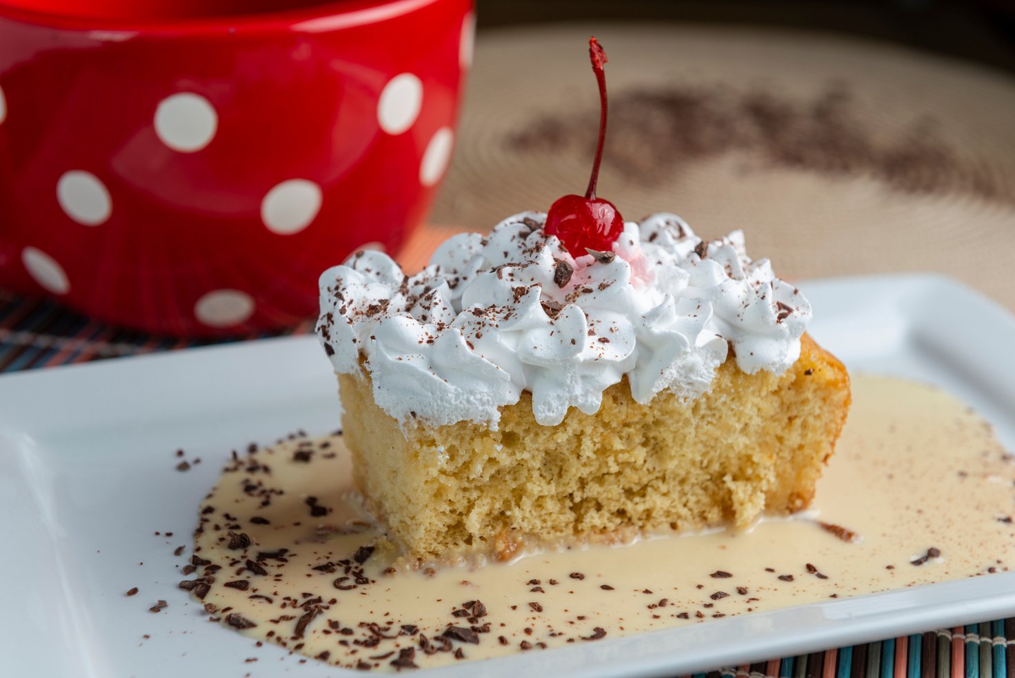 Three milk cake, tres leches cake with cherry and chocolate. Traditional dessert of Latin America.